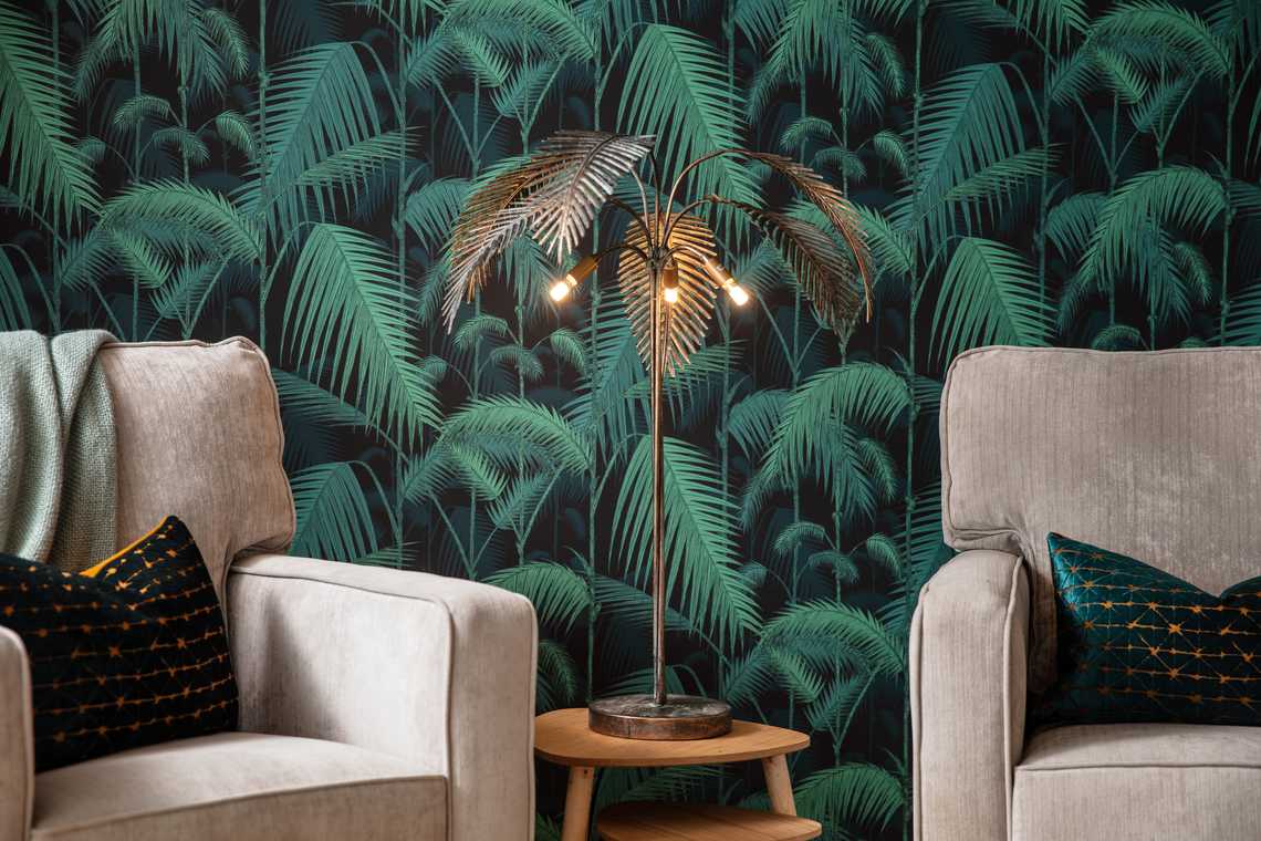 two armchairs with statement palm wallpaper